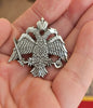Large-scale handcrafted Orthodox double headed eagle crest lapel pin held on a hand for size reference