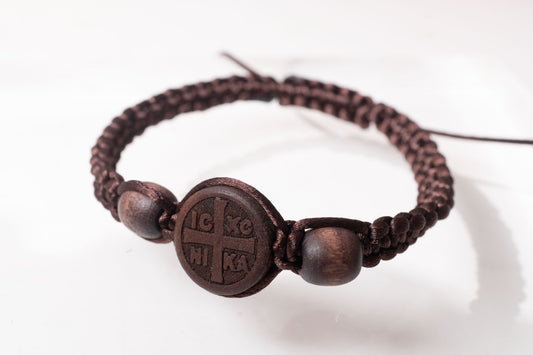 Ultra close-up view of the handcrafted earth brown macrame Christian prayer bracelet with matching wooden beads and round IC XC NIKA emblem