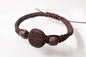 Ultra close-up view of the handcrafted earth brown macrame Christian prayer bracelet with matching wooden beads and round IC XC NIKA emblem