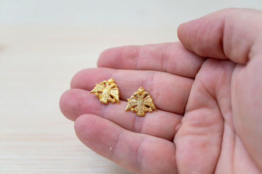 Handcrafted Orthodox double headed eagle crest pins on a hand for size reference