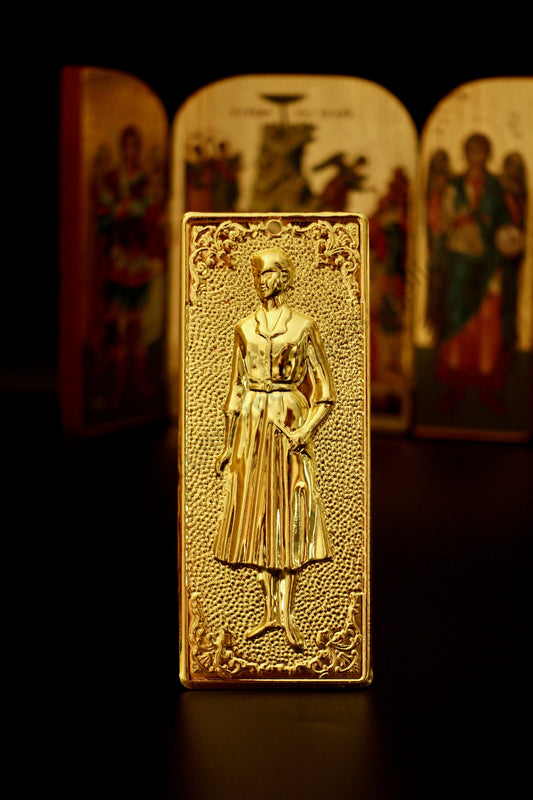 Plain gold-tone Greek Orthodox tama votive offering plaque embossed with a woman figure and a small pre-drilled top hole for hanging.