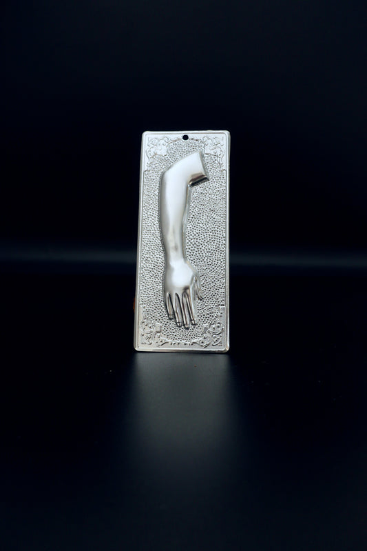 Plain silver-tone Greek Orthodox tama votive offering plaque embossed with a left human arm and hand design and a small pre-drilled top hole for hanging.
