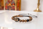 Handcrafted Christian bracelet made of natural grained brown wooden beads with an engraved IC XC NIKA cross centerpiece