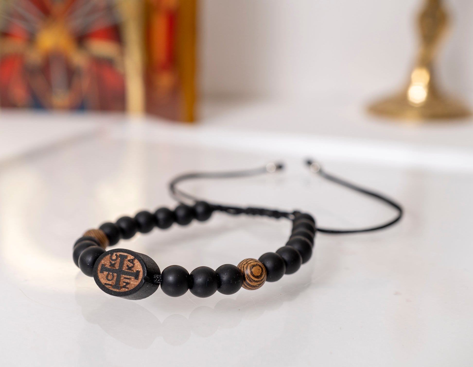Handcrafted Orthodox Komboskini bracelet featuring matte black wooden beads and an engraved IC XC NIKA cross emblem