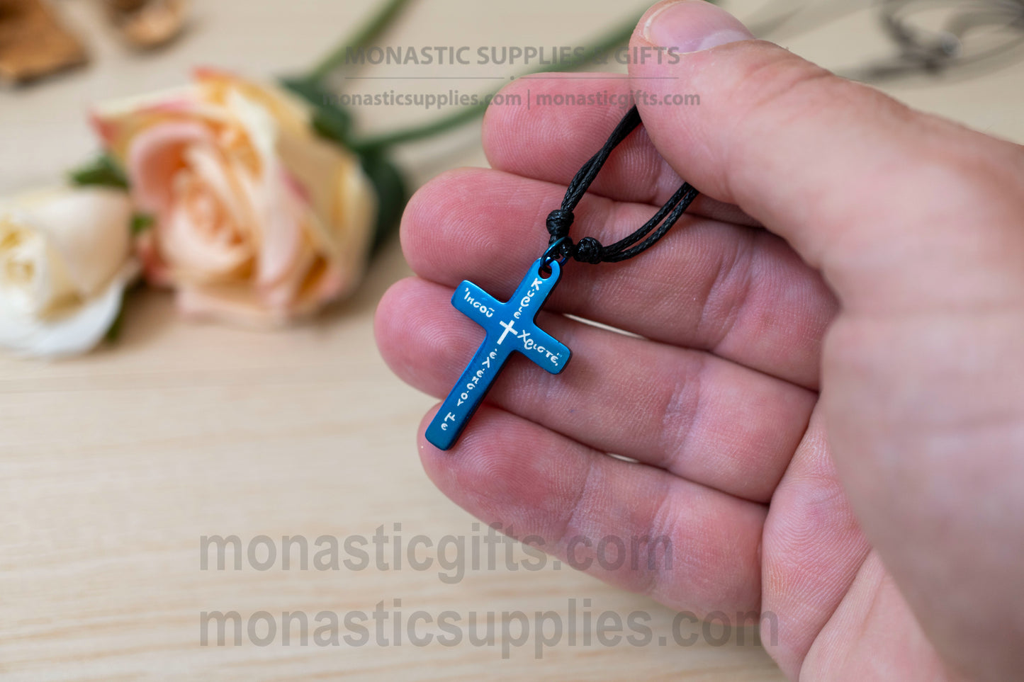 Orthodox blue metallic cross necklace engraved with the Jesus Prayer in Greek.