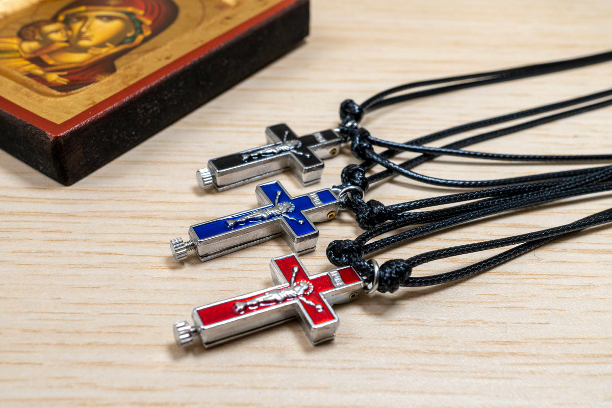 Opening metal reliquary cross pendant with enamel in black blue and red on adjustable genuine leather cord
