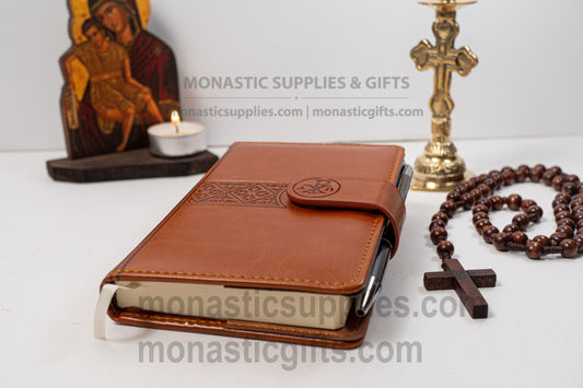 Engraved brown leather Christian notebook featuring an embossed IC XC NIKA cross symbol, magnetic closure, ribbon bookmark, and luxury Jesus Prayer pen, measuring 11x15 cm.