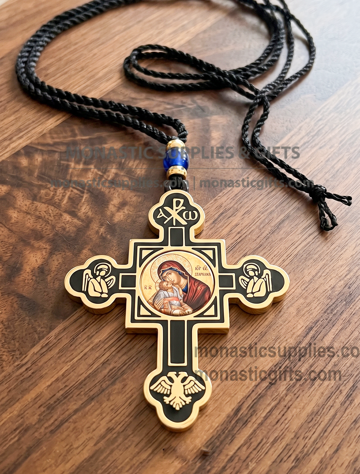 Byzantine double-sided hanging cross protection amulet with gold and black accents, featuring an Orthodox icon of Virgin Mary on one side and Jesus Christ on the reverse, Chi-Rho symbol at the top, praying angels, and a double-headed eagle on a wooden surface.