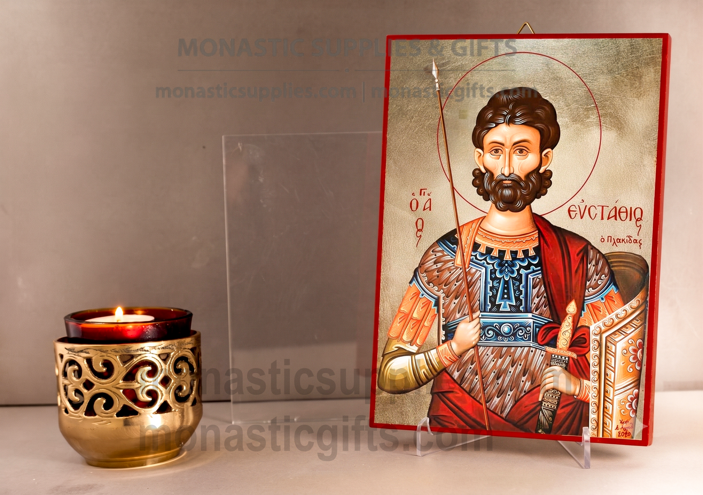A Byzantine-style religious icon of Saint Eustathios on a clear acrylic stand, displayed next to a lit gold-toned candle holder against a neutral background.