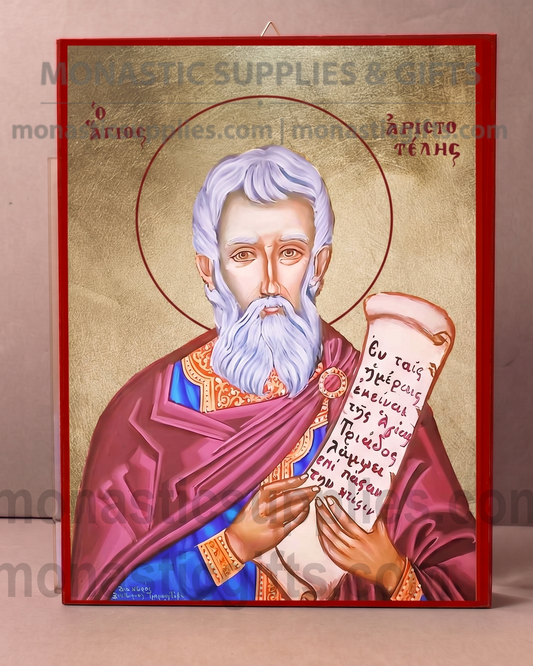 A religious icon plaque of Saint Paul holding a scroll, featuring a gold background, red and purple robes, and a red border, displayed against a neutral beige background.